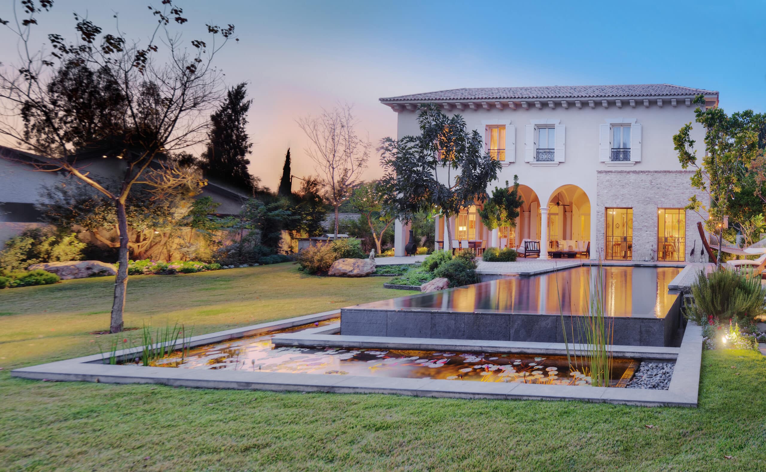 Luxury home with reflecting pool at dusk